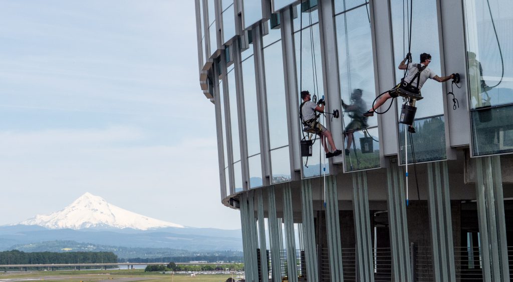 Workers clean the windows at the Port's headquarters with Mt. Hood in the background